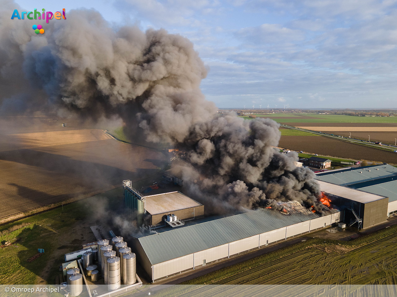 Foto behorende bij Vlammen slaan uit dak van brandende loods