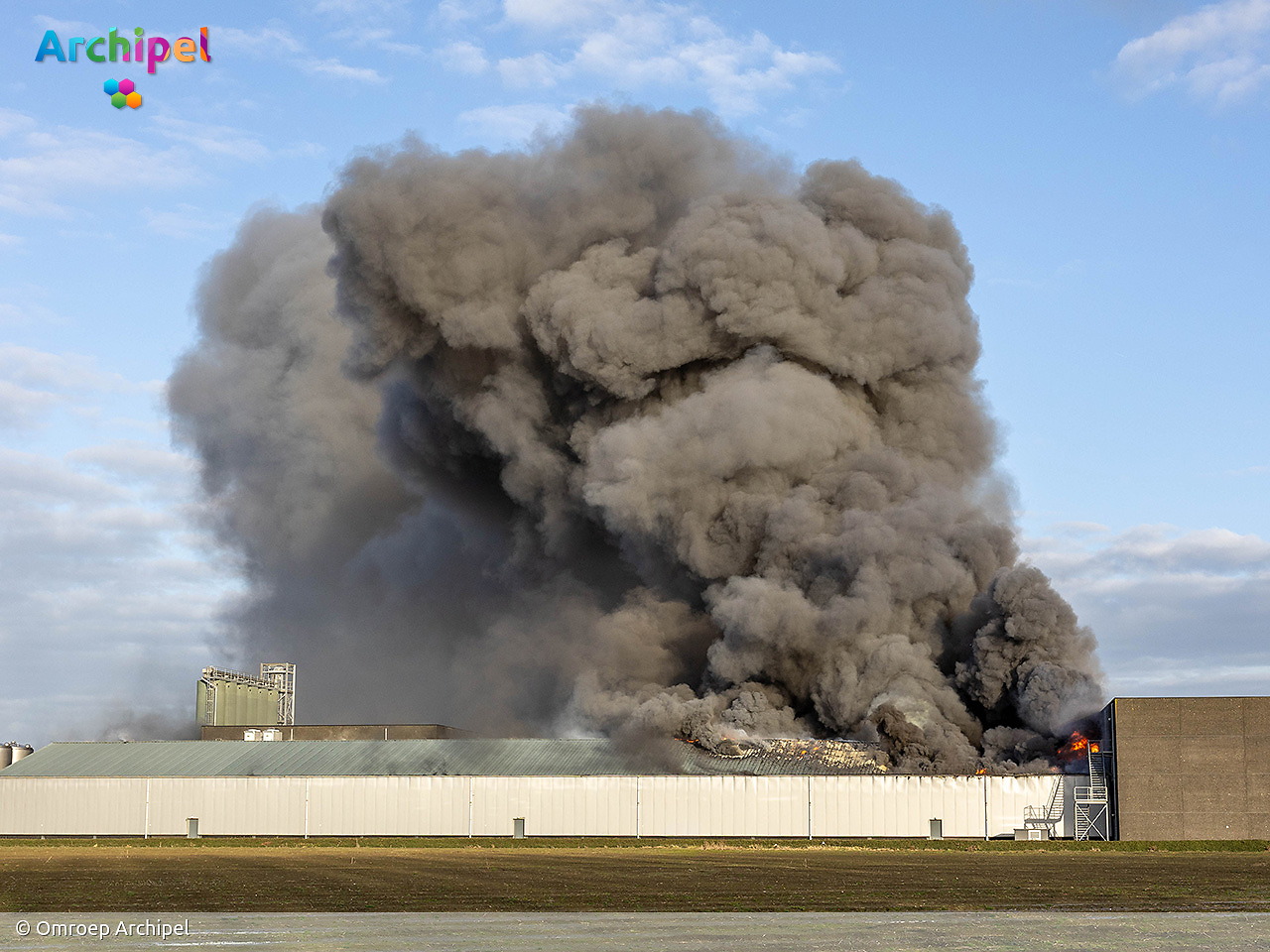 Foto behorende bij Vlammen slaan uit dak van brandende loods