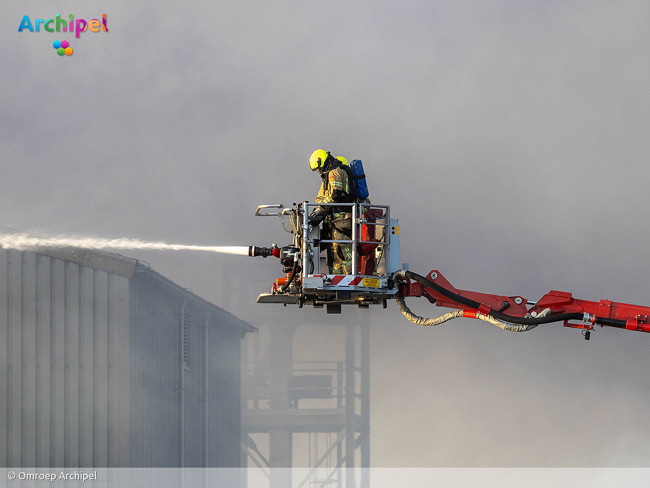 Foto behorende bij Vlammen slaan uit dak van brandende loods