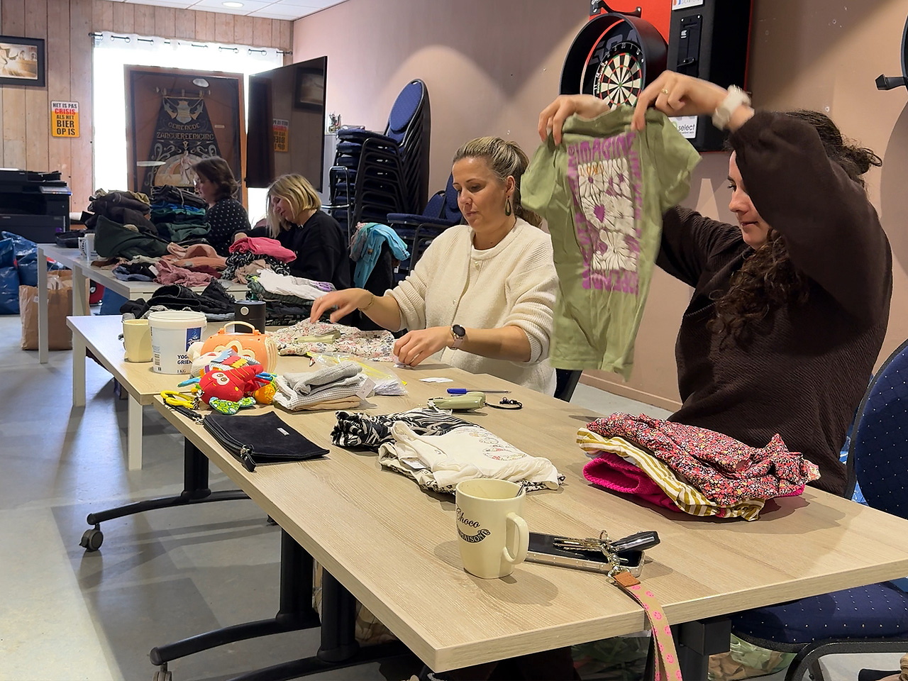 Vrijwilligers duiken in berg kledingzakken - FlakkeeNieuws Goeree-Overflakkee