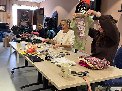 Vrijwilligers duiken in berg kledingzakken