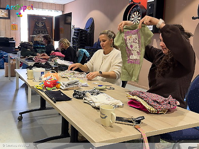 Vrijwilligers duiken in berg kledingzakken